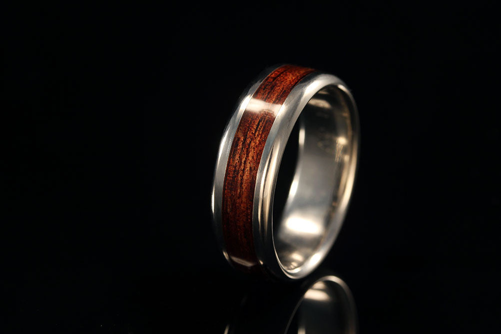 sideview of titanium ring, upright view with silver inner band and Koa wood band, Chasing Victory