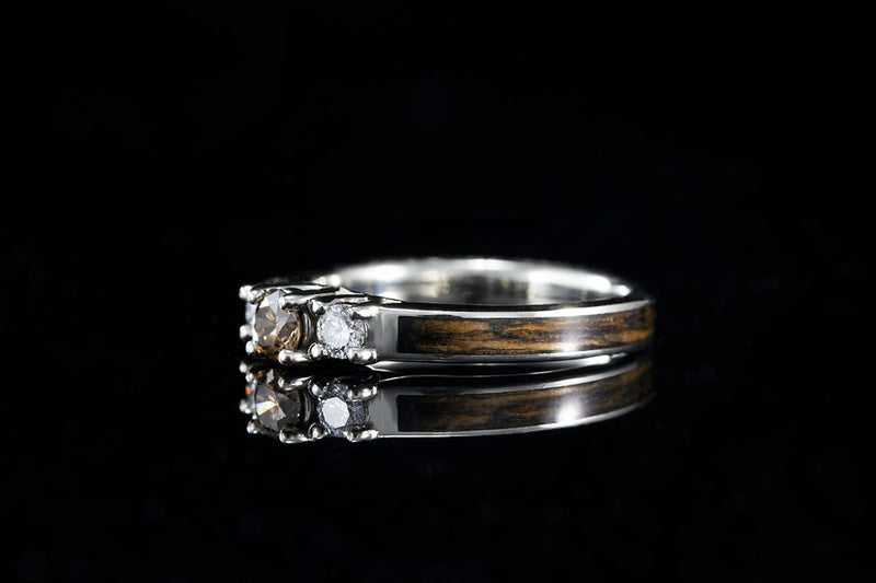 Side view of 3-stone Whiskey Barrel Wood Engagement ring, brown center diamond flanked by two white diamonds, brown wood inlay